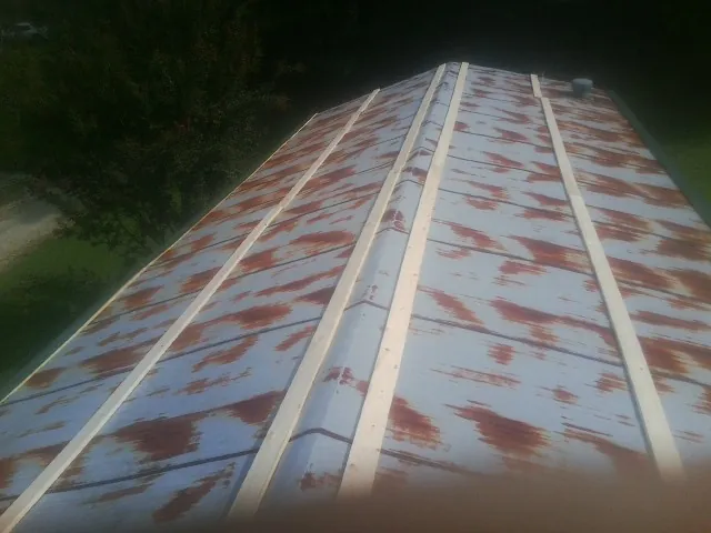 Rusted metal roof panels with new wood purlins before replacement — Storm Damage Roof Repair in Roseville by Roofing Brothers